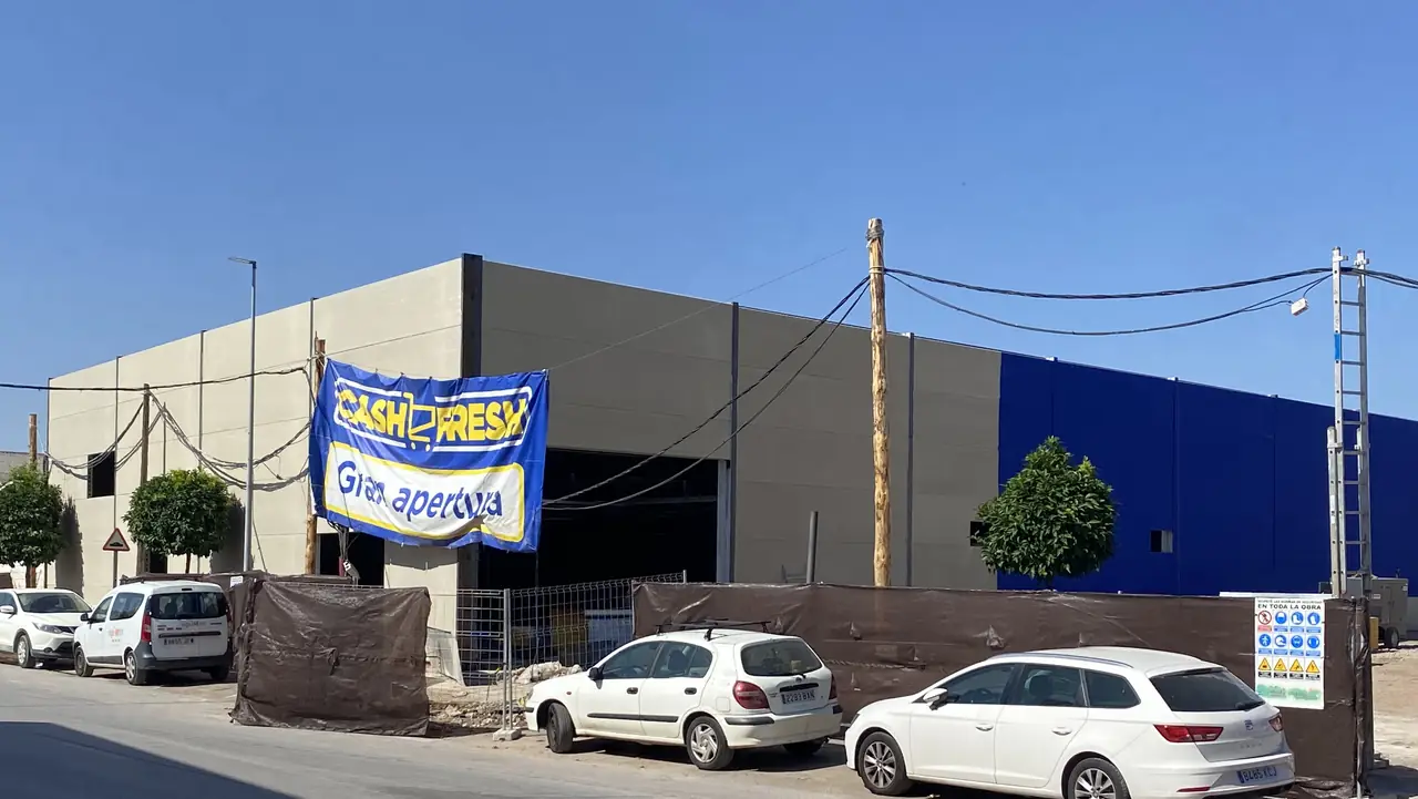Esquina del hipermercado con el cerramiento de placas alveolares y el cartel de gran apertura