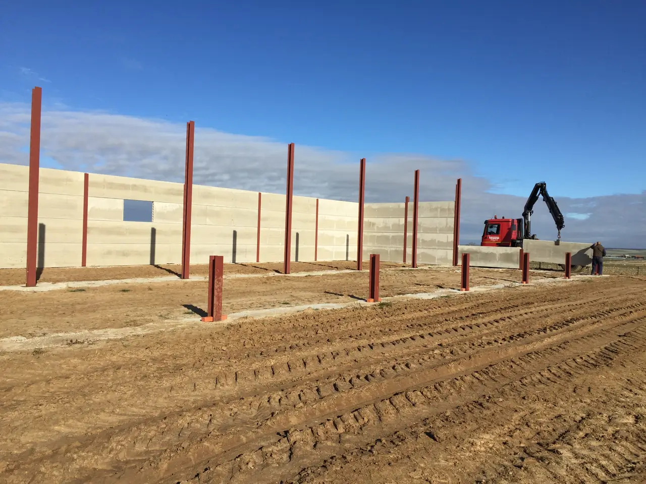 Camión grúa de Estrucserena colocando una placa, con un operario guiando la maniobra
