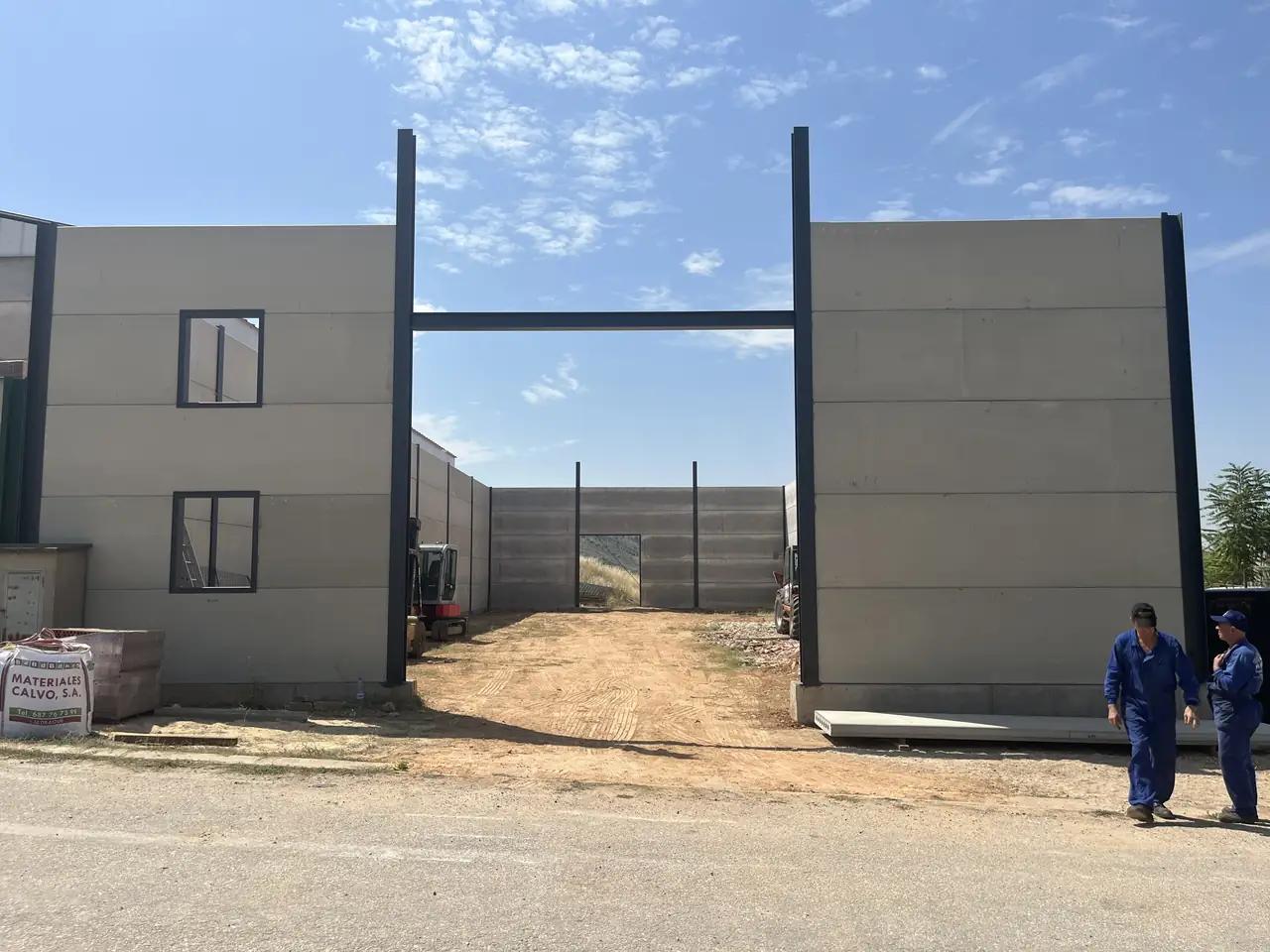 Hueco de acceso y fachada con ventanas, con operarios en primer plano