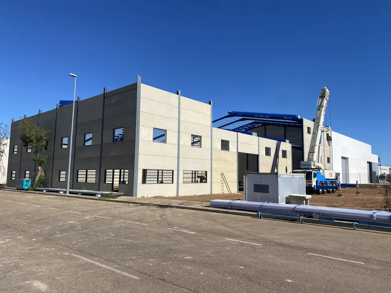 Fachada de la nave con cerramiento de placas alveolares y ventanas