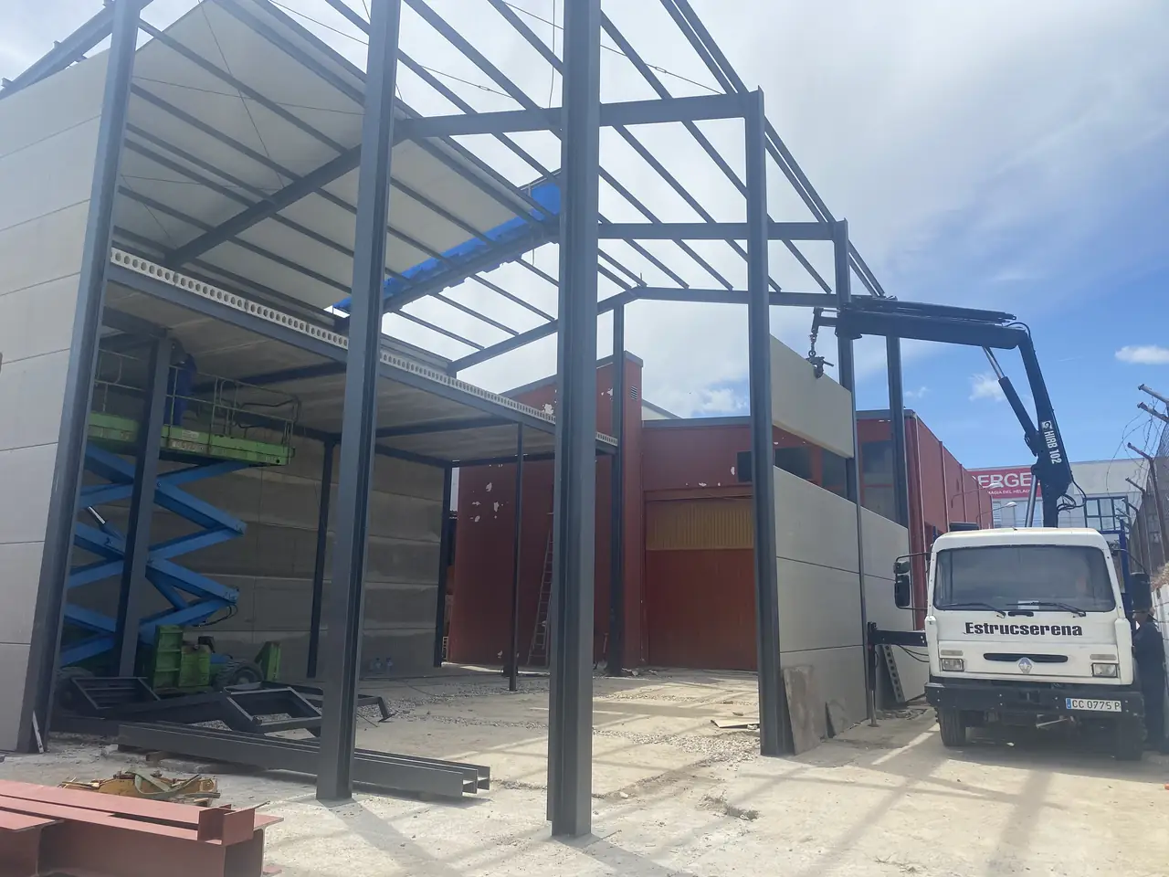 Nave en montaje con la estructura, la entreplanta y los muros de placas, con el camión grúa de Estrucserena