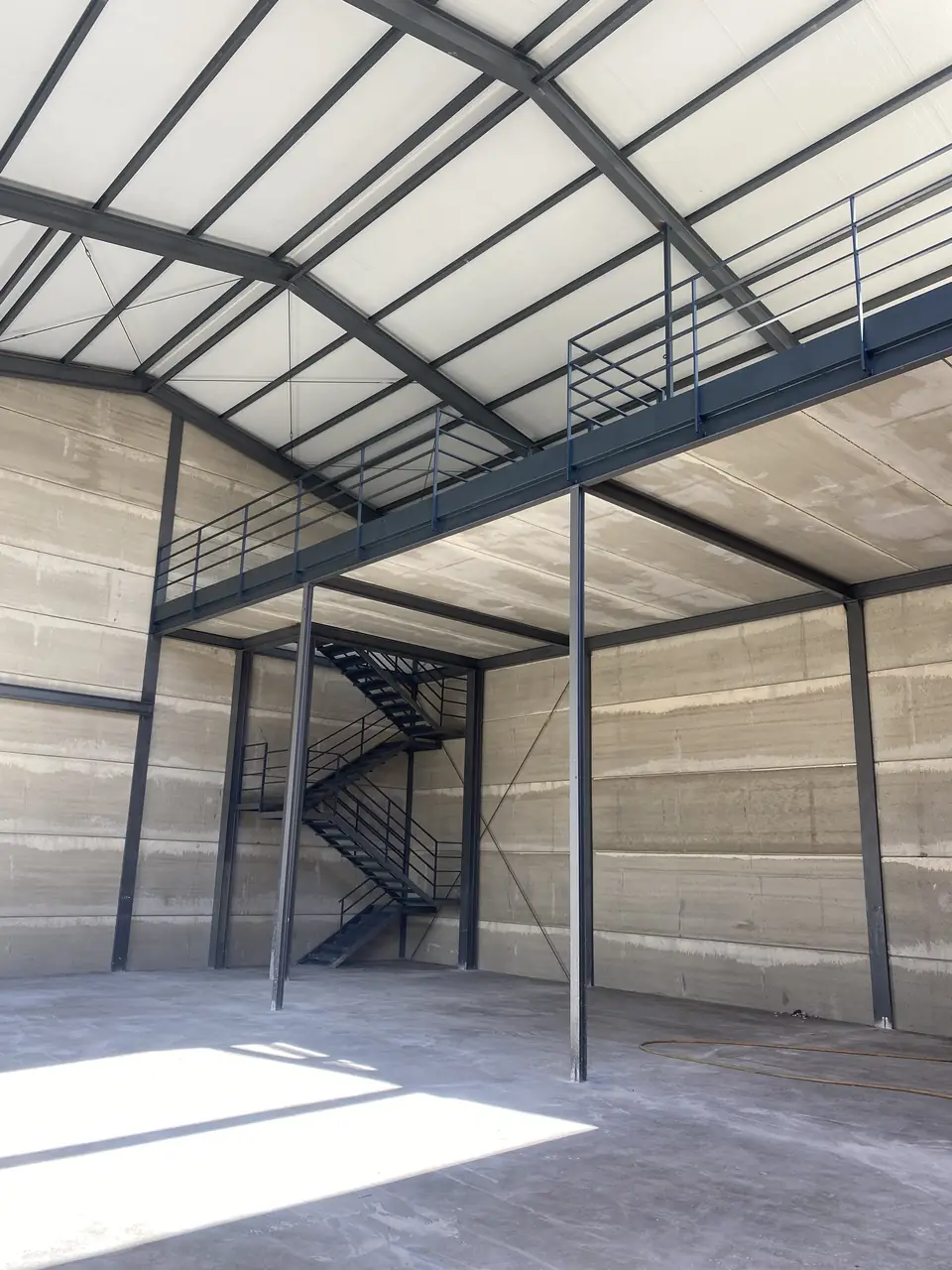 Interior de la nave con la entreplanta, su barandilla y la escalera