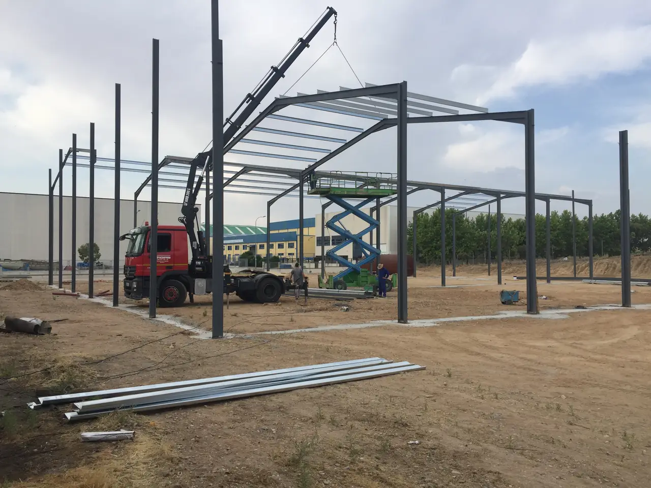 Camión grúa y plataforma elevadora durante el montaje de la estructura