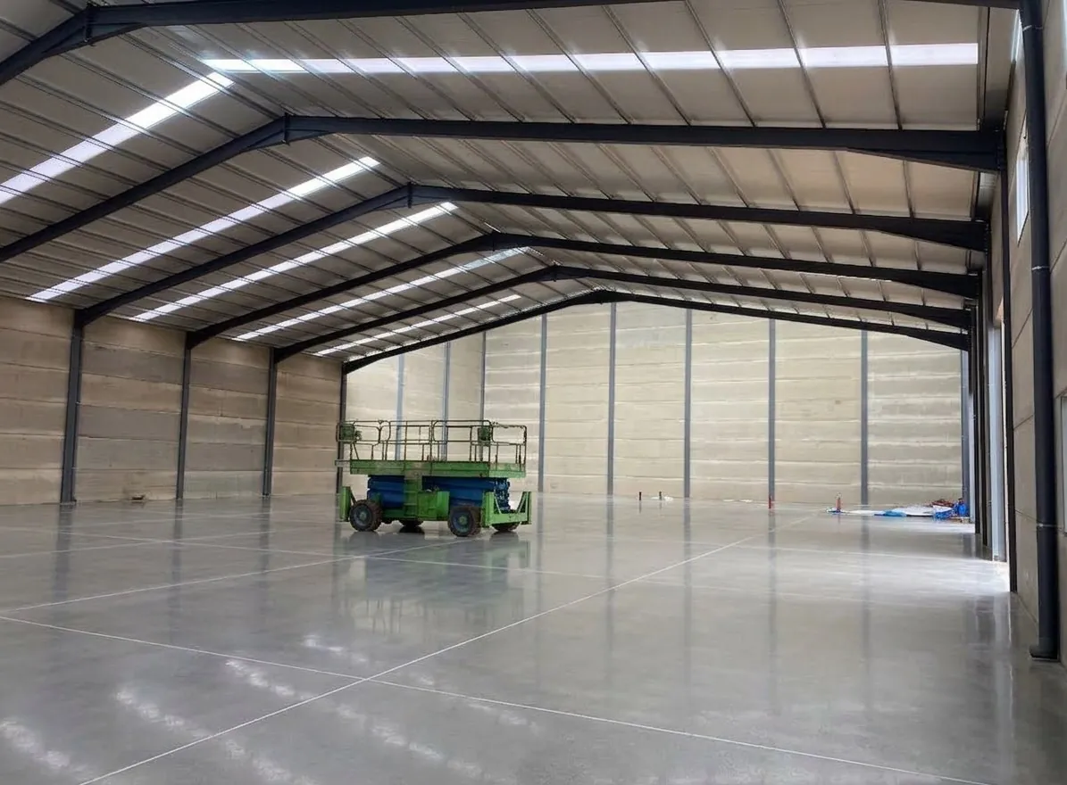 Nave industrial terminada, interior con solera de hormigón